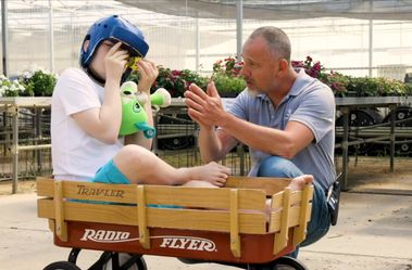 Still from video featuring MyPath employee and child in wheelbarrow